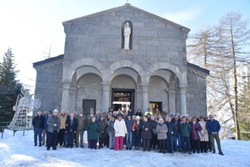 Gruppo di persone davanti ad una chiesa per l'accensione dell'albero di Natale