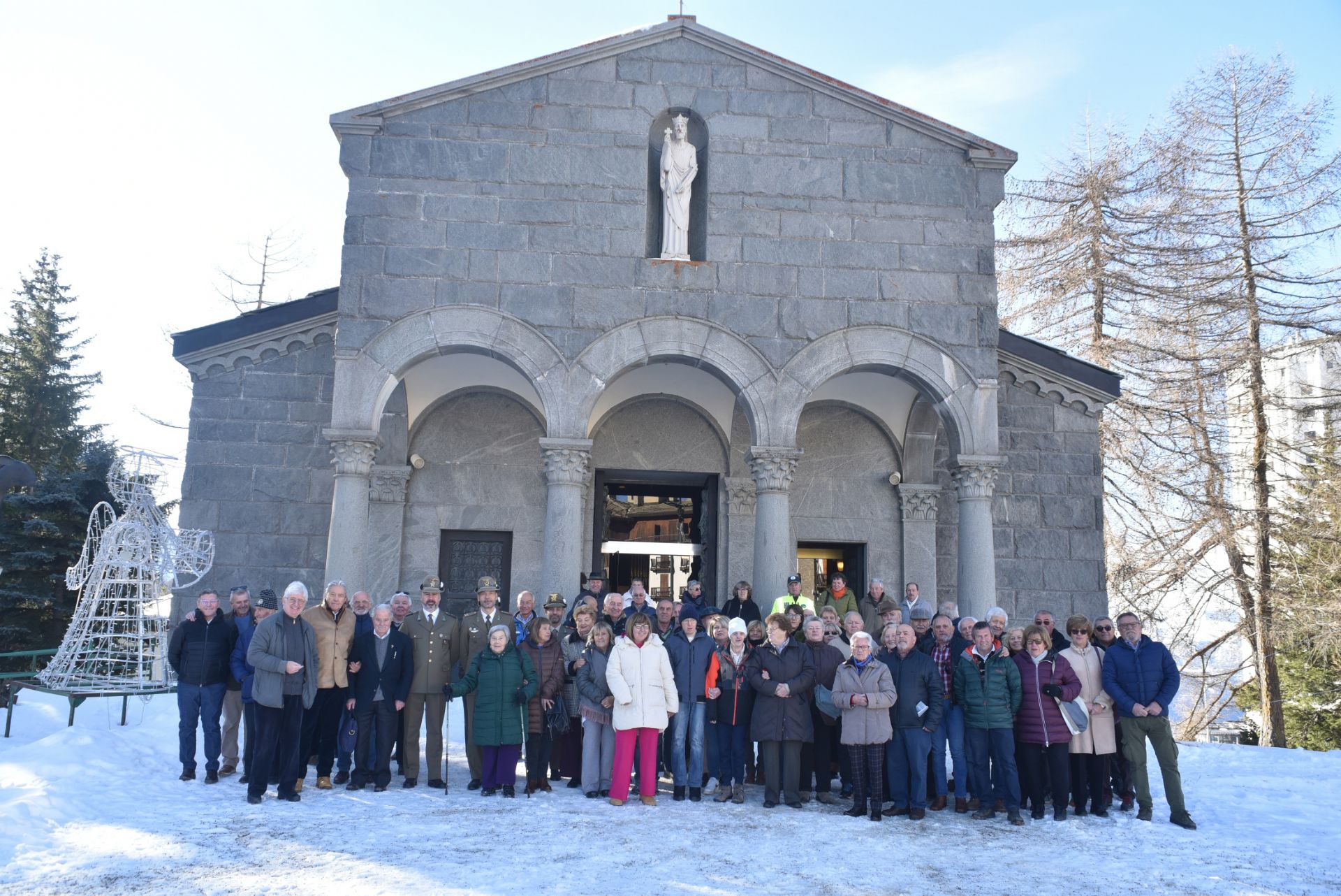 Gruppo di persone davanti ad una chiesa per l'accensione dell'albero di Natale
